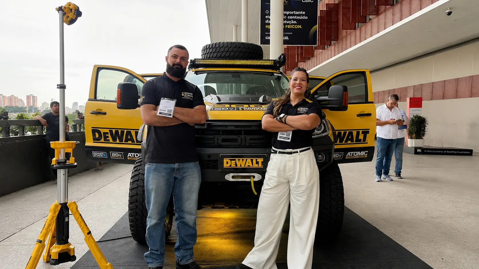 Equipe Contato Elétrico em evento, ao lado da picape DeWalt